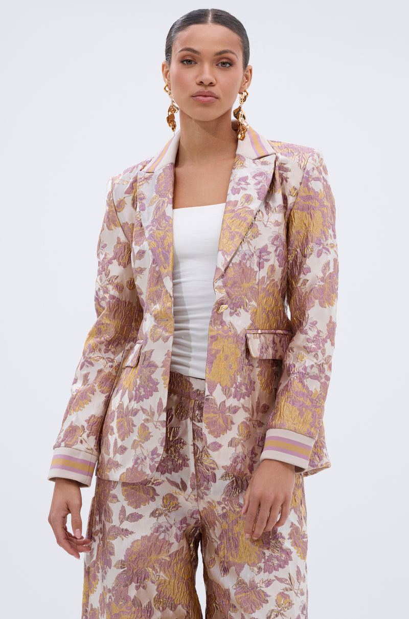 A woman wearing the SLOW MOTION BROCADE BLAZER in pink and gold metallic floral.