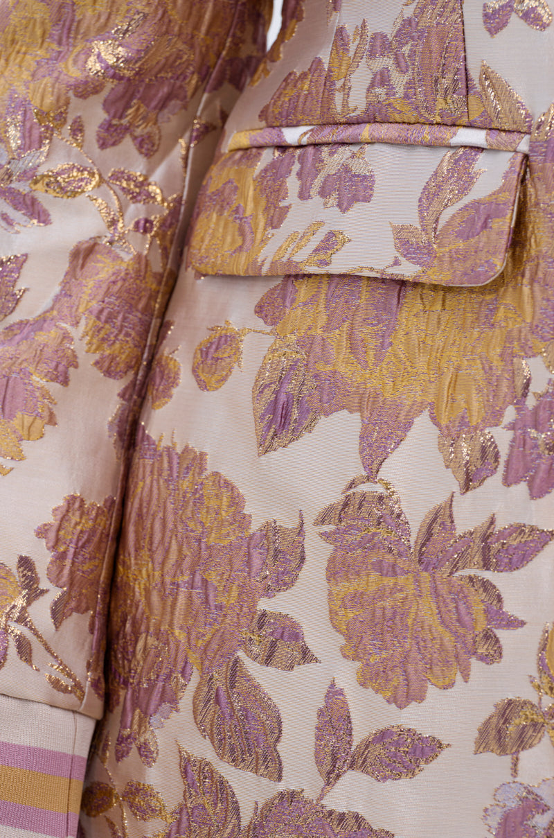 Close-up of the SLOW MOTION BROCADE BLAZER featuring a light pink floral pattern, gold and lavender embroidery, detailed texture, and the pocket flap.