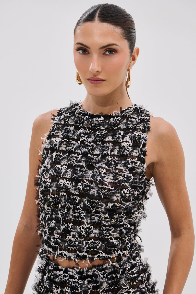A woman with sleek dark hair in a low ponytail wears gold hoop earrings and the CRAZY FOR YOU FRINGE TANK, featuring a black and white cropped silhouette. She stands against a plain light background, looking confidently at the camera. 0