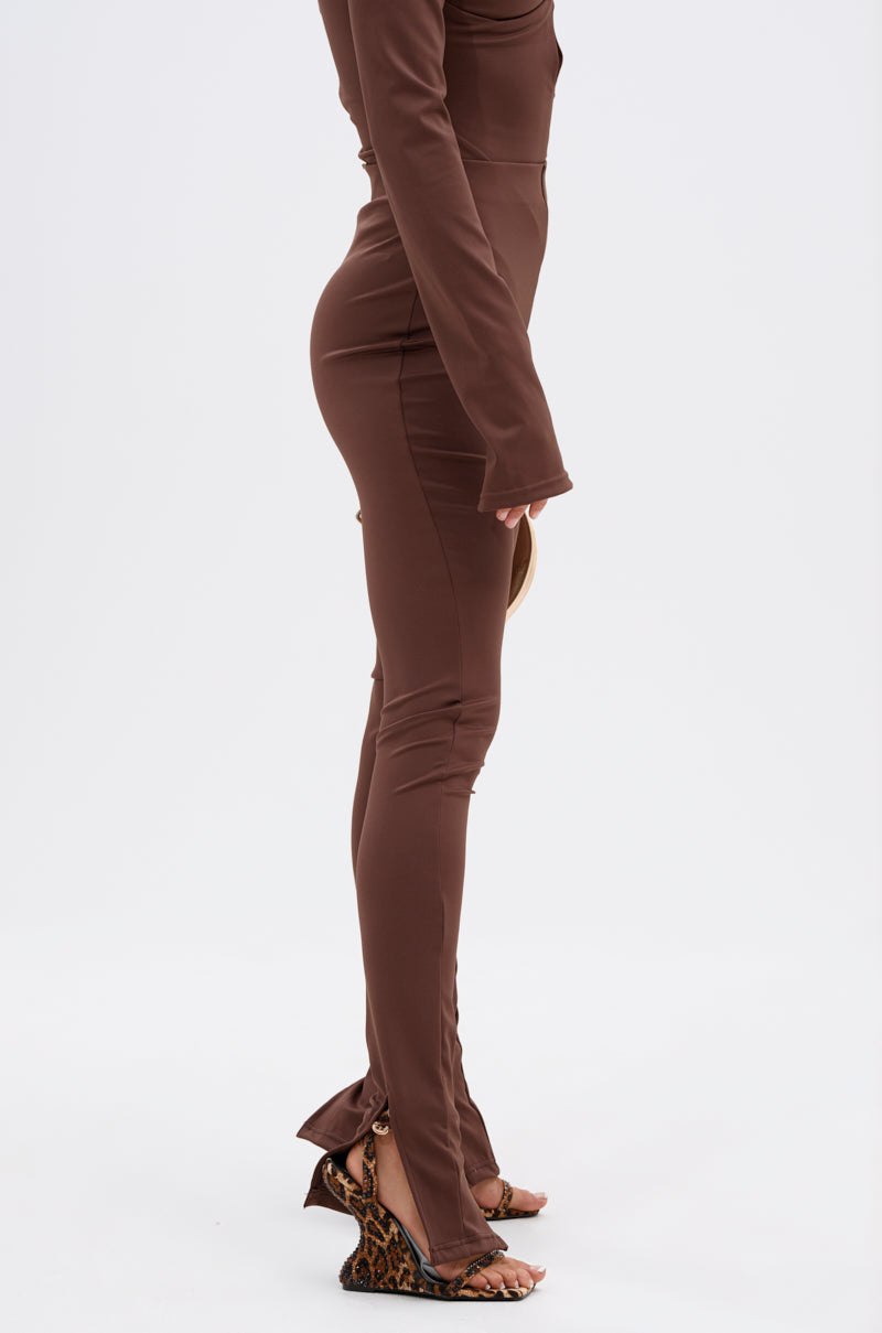 A person in profile wears the LUX LIFE SEAMLESS LEGGING IN BROWN, styled with a round clutch and leopard print wedge heels against a plain white background. 2