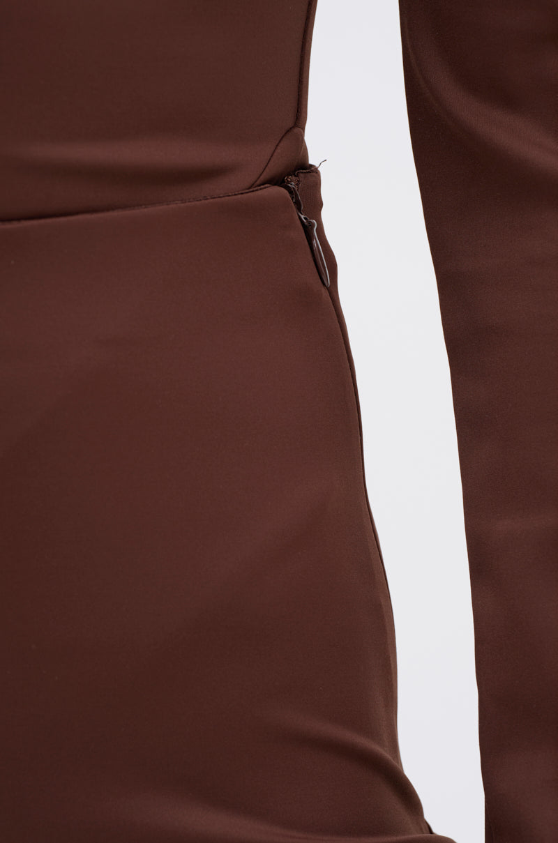 Close-up of the LUX LIFE SEAMLESS LEGGING IN BROWN, highlighting sculpted fabric at the side seam and a partially visible zipper, with part of a long sleeve shown against a white background. 5