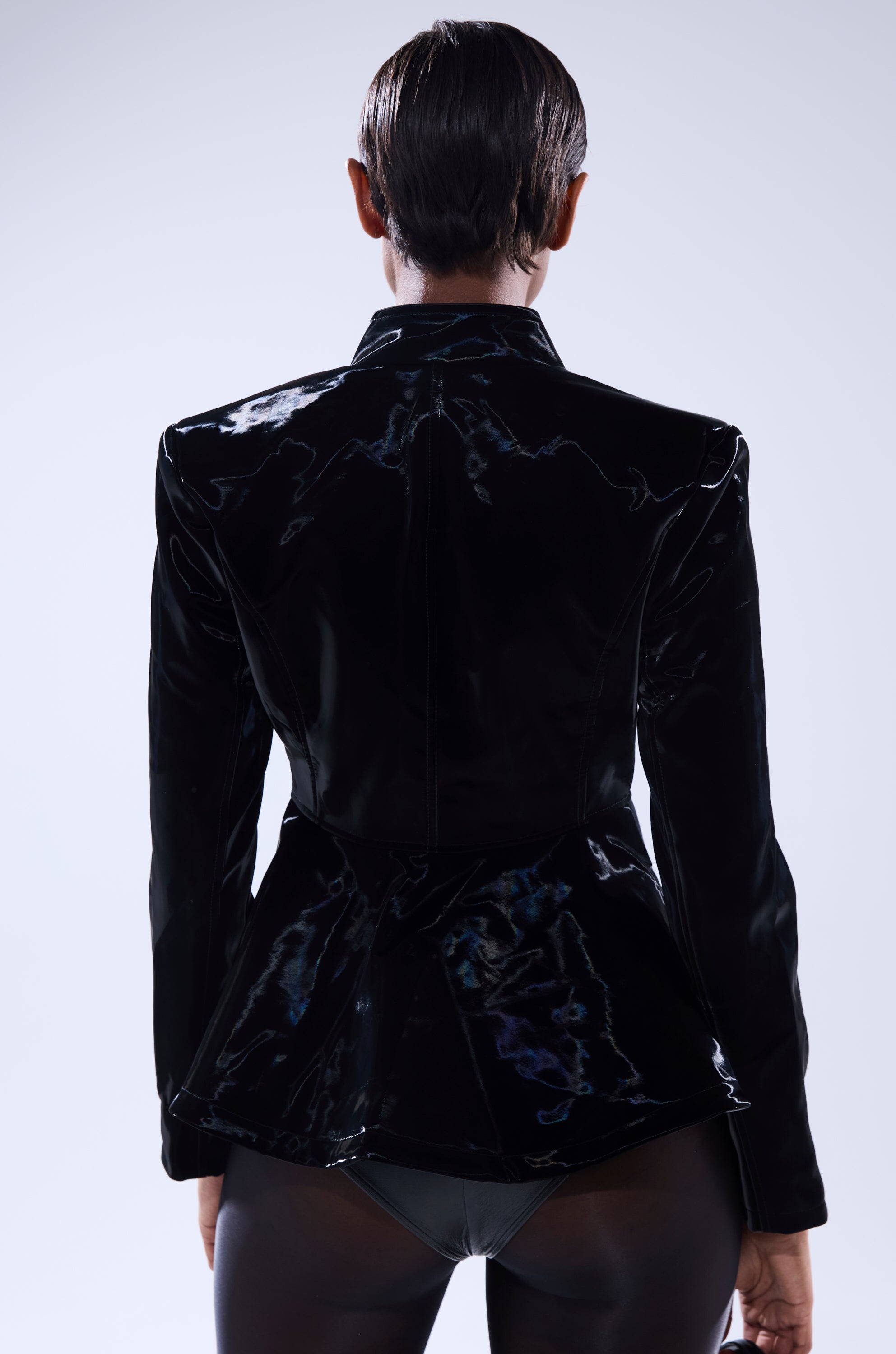 A person with short, slicked-back hair is shown from behind, wearing the SLIMM LIQUID VELVET BLAZER with dark bottoms against a plain light background. 4