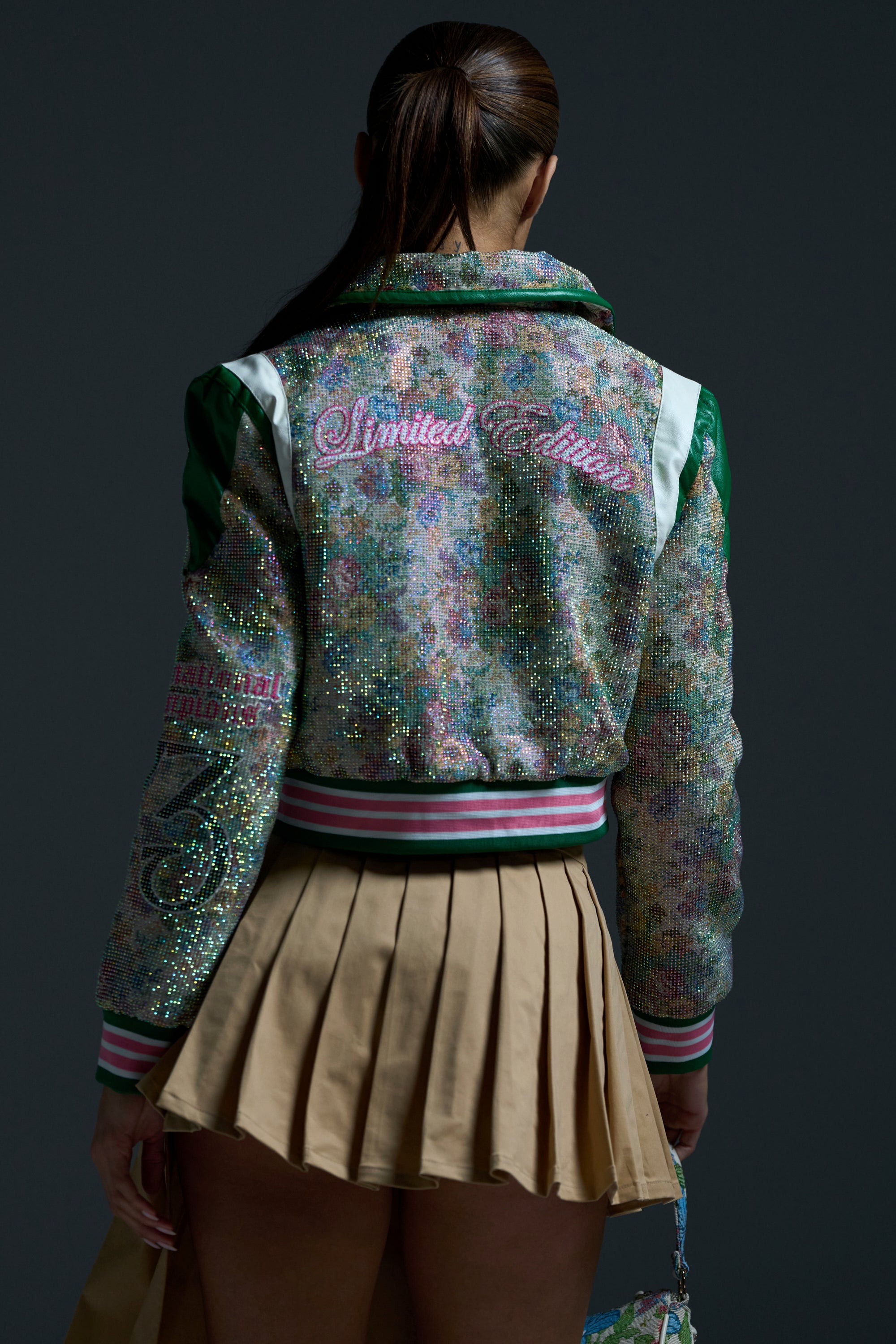 A woman wearing the TAPPED OUT RHINESTONE BOMBER, featuring brocade fabric and faux leather trim.