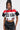 A person confidently poses against a plain background, wearing a stylish ensemble that includes the OFFICIAL DUTY CROPPED BUTTON DOWN TOP, featuring bold letters and a sporty color block pattern, paired with black faux leather shorts.