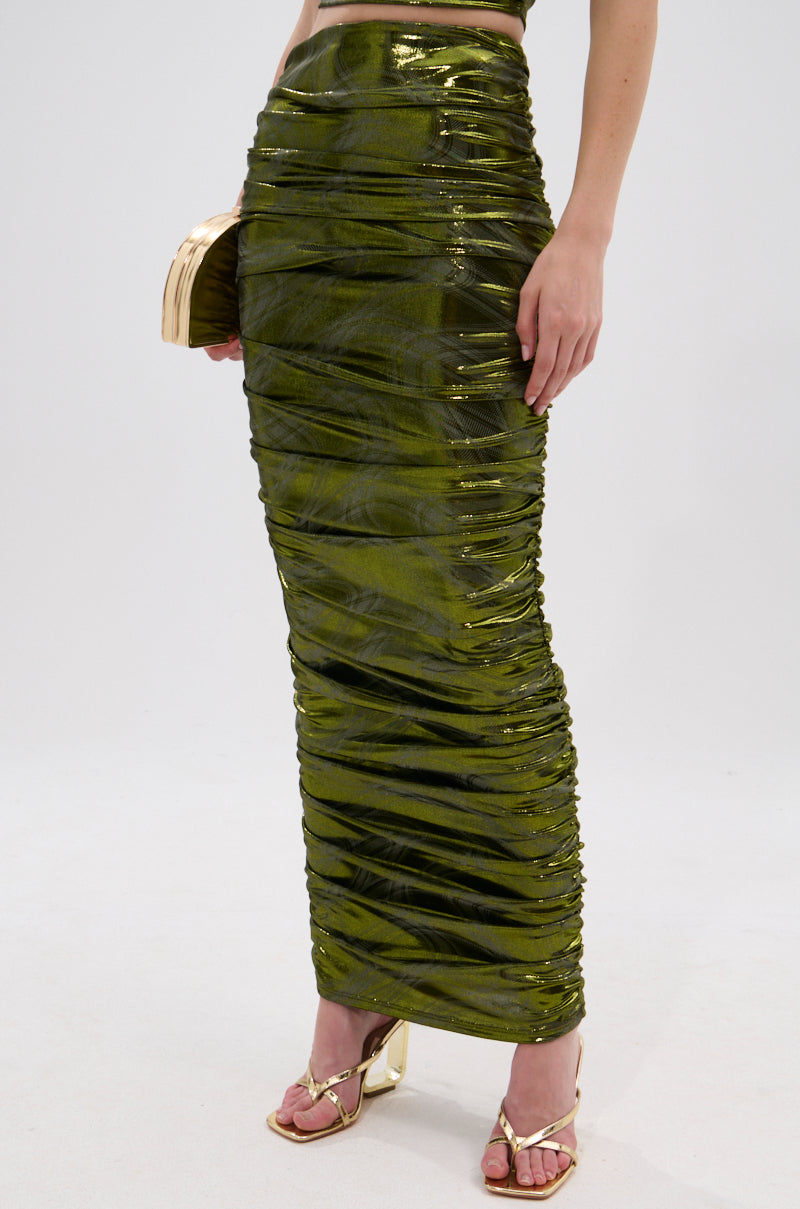 A person showcases the TAYLOR METALLIC RUCHED MAXI SKIRT with matching strappy heels and a gold clutch, their lower half visible against a simple light background. 2