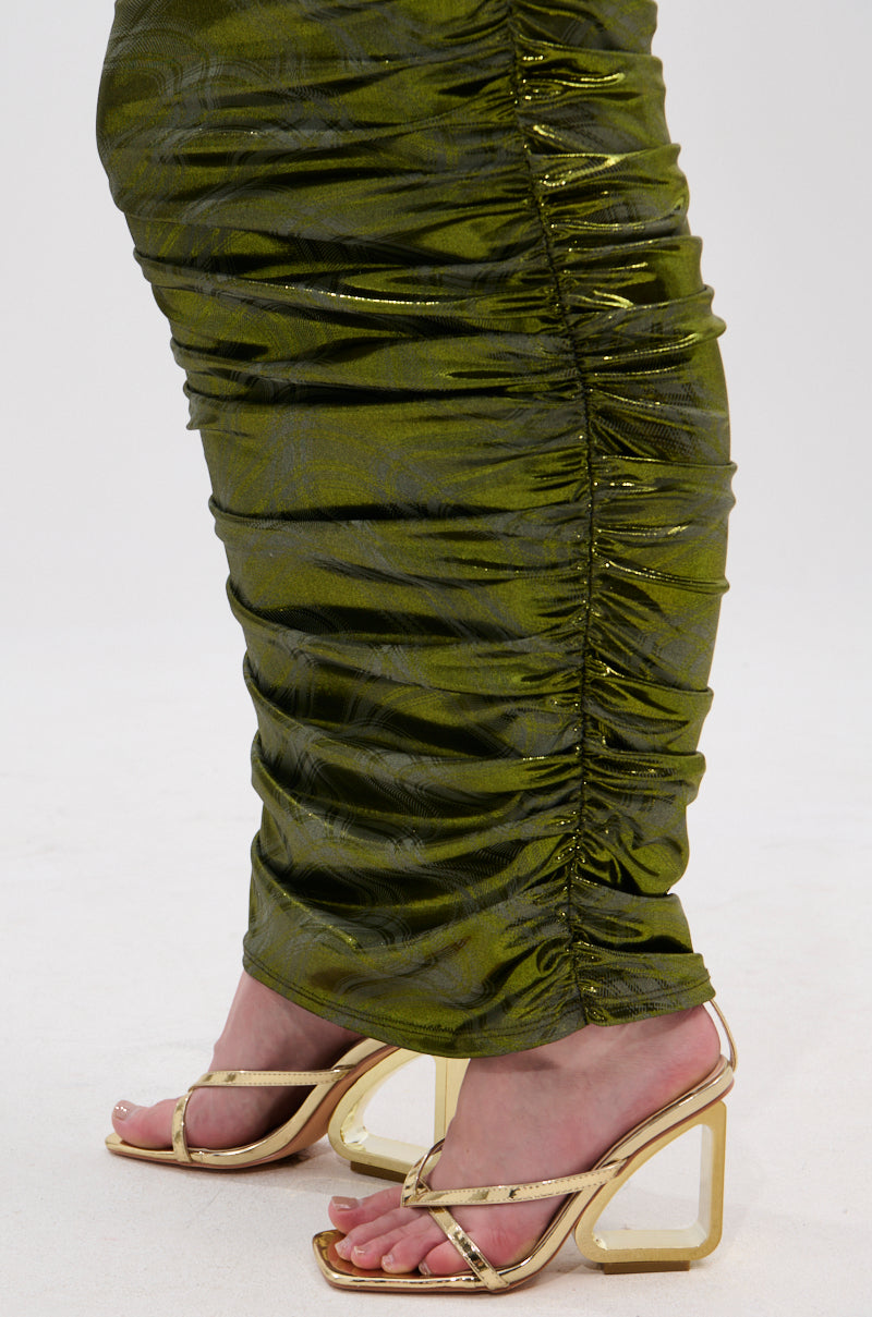 Someone wearing the TAYLOR METALLIC RUCHED MAXI SKIRT in olive green with gold open-toe heels featuring clear block heels, standing on a light-colored surface. 8