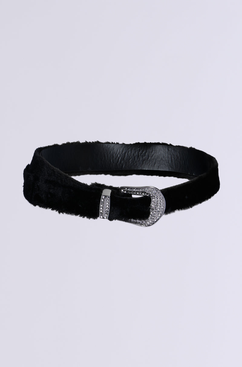 The MIDNIGHT SKIES FUR BELT showcases a sleek black velvet texture with a metallic silver buckle adorned with shimmering silver rhinestones, elegantly displayed on a plain white background.