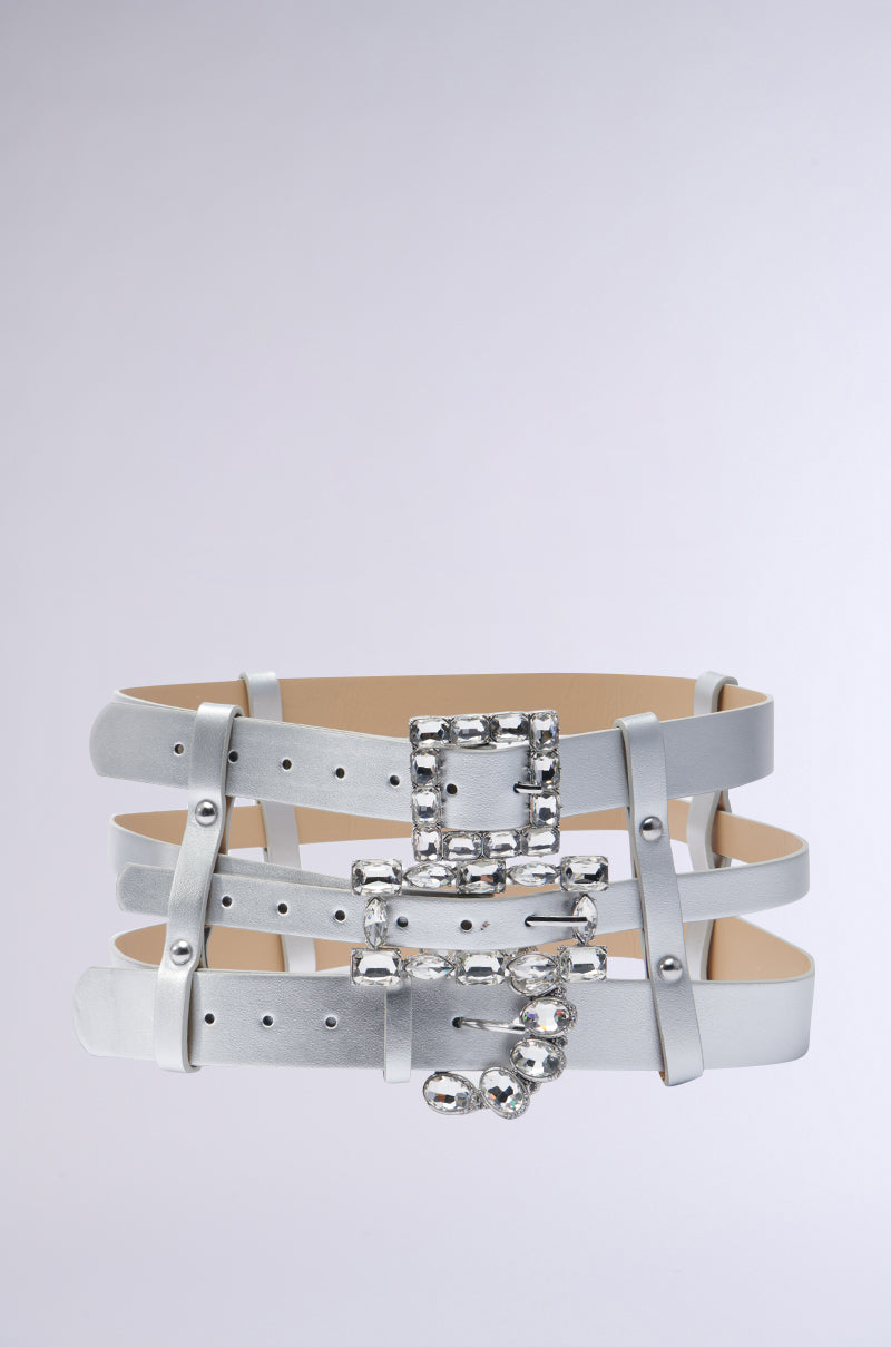 Add a touch of glamour to your outfit with the GET ON MY LEVEL MULTI BUCKLE BELT. This waist-cinching accessory features a metallic silver faux leather finish, adorned with three straps that showcase shiny, ornate buckles and studs against a sleek gray background. 0