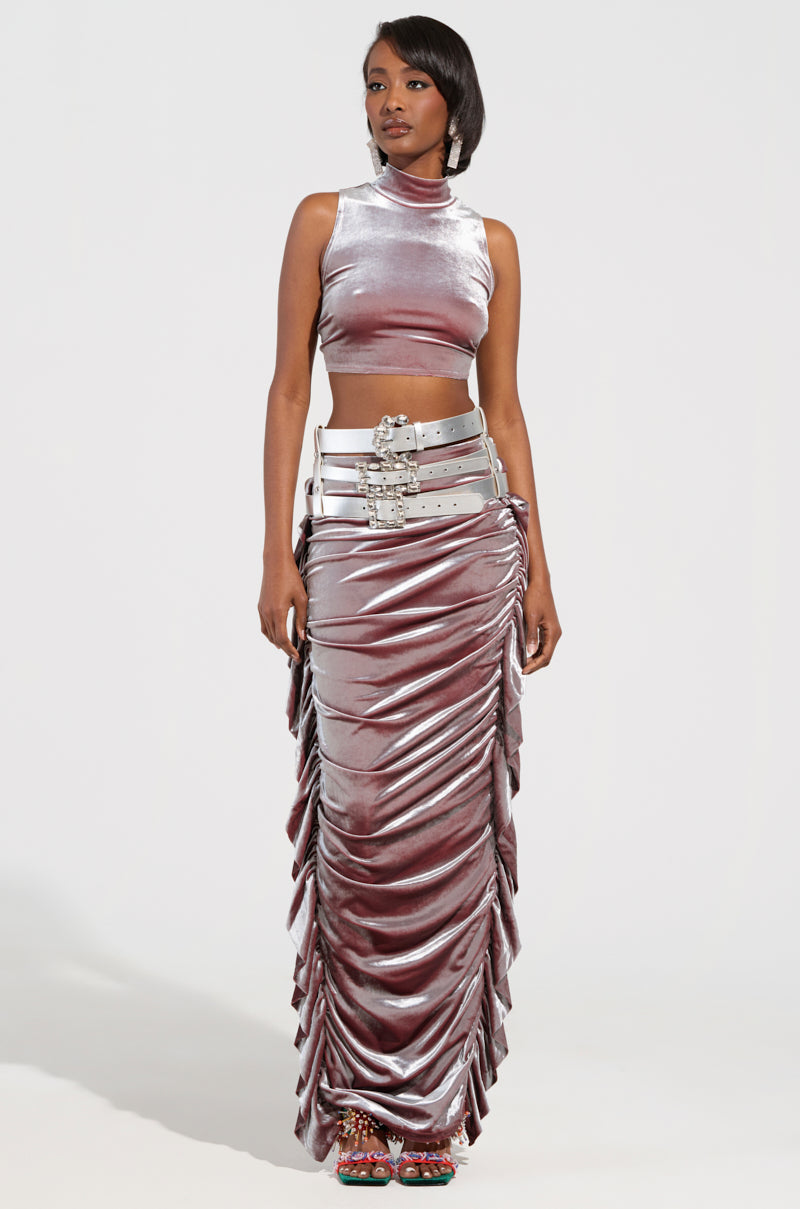 A person wears the "GET ON MY LEVEL MULTI BUCKLE BELT" two-piece outfit, featuring a shiny silver ensemble with a sleeveless crop top and a long skirt. The metallic silver faux leather gleams against the plain white background, while the skirt is adorned with multiple buckle belts around the waist, providing stylish waist-cinching details. 2