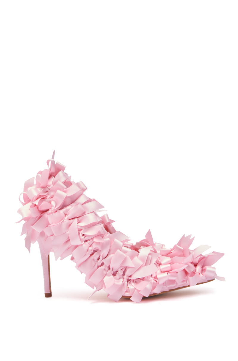 The AZALEA WANG STACIA PINK BOW PUMP is a high-heeled shoe with layered, ruffled pink ribbon details for a textured, floral look, plus a pointed toe and chic stiletto heel.