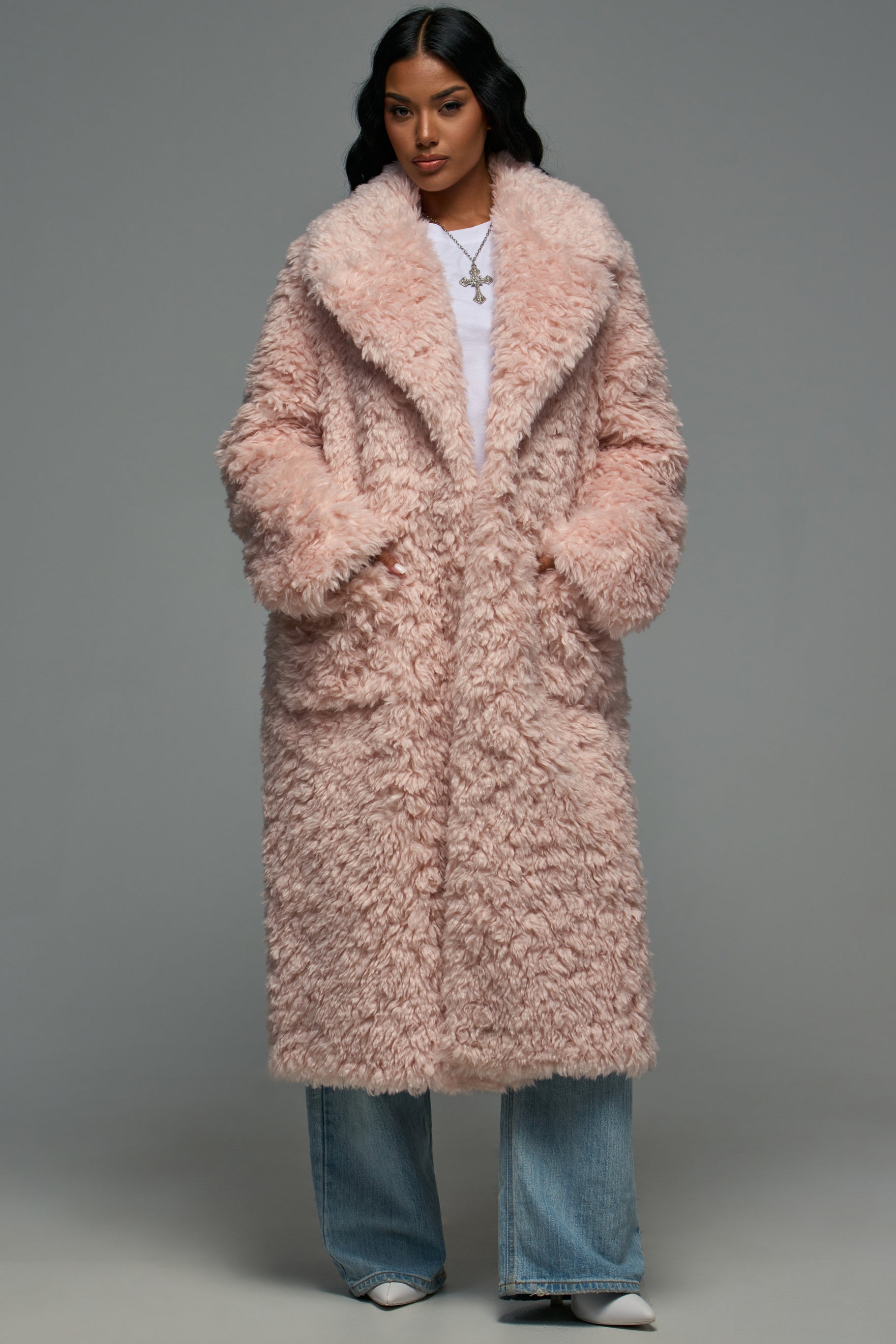 A person wearing a STELLA WOOL BLEND FAUX FUR LIGHT PINK COAT over a white shirt and light-wash jeans for a winter streetwear look.