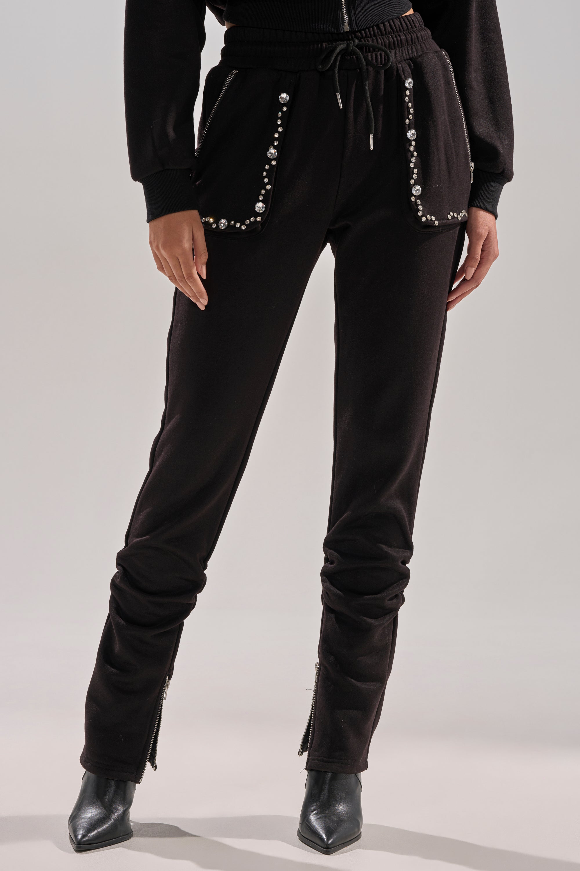 Wearing the COZY HOLIDAY RHINESTONE JOGGER IN BLACK with pointed ankle boots and a black jacket creates a chic, stylish look perfect for fans of rhinestone joggers.