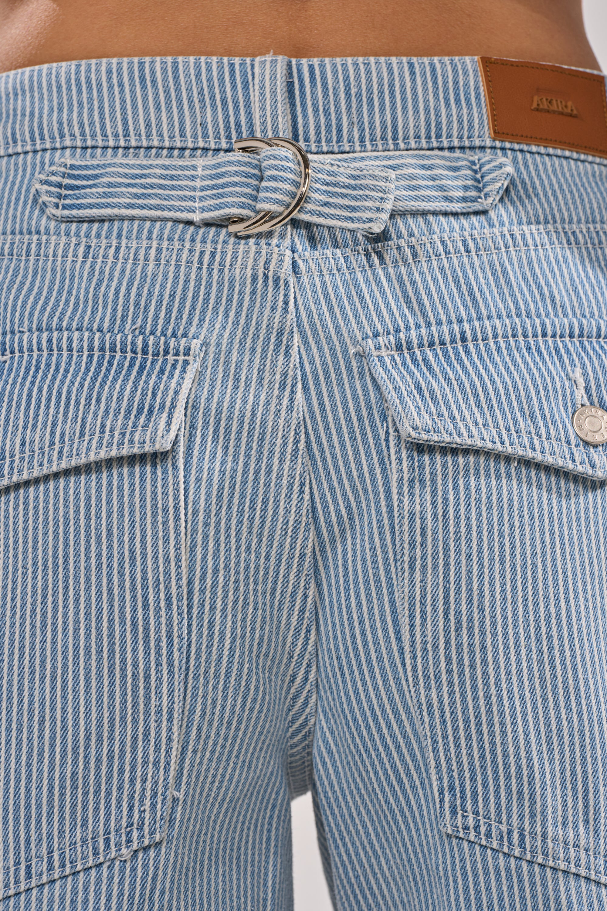 Close-up of the back of FEEL FREE STRIPE GAUCHO, vintage-inspired striped denim bermuda shorts with a mid-rise, two back pockets, belt loop with silver D-ring, and brown leather brand patch on the waistband. 8