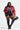 A person poses confidently wearing a red faux fur jacket, a plaid top, and black leather shorts paired with the AZALEA WANG Surgical Flatform Boots with 4-Way Stretch in Stretch PU. They hold a black studded handbag and wear hoop earrings, standing against a plain background.