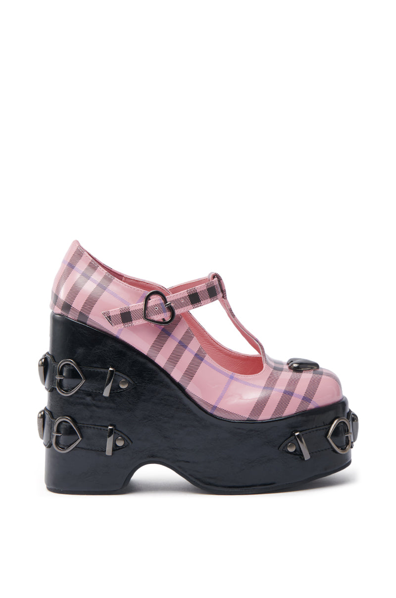 The KOI FOOTWEAR SWEET APATHY PINK HEART WEDGE PUMP is a platform Mary Jane with a pink plaid upper, chunky heel, heart-shaped strap buckle, and heart hardware accents on the side. 2