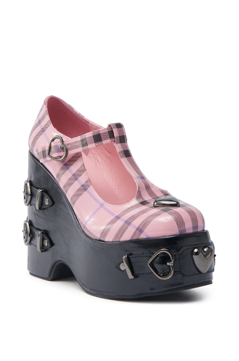 The KOI FOOTWEAR SWEET APATHY PINK HEART WEDGE PUMP features a pink and black plaid pattern, chunky heel, rounded toe, top strap, and metal heart-shaped buckles with hardware accents for added style. 3