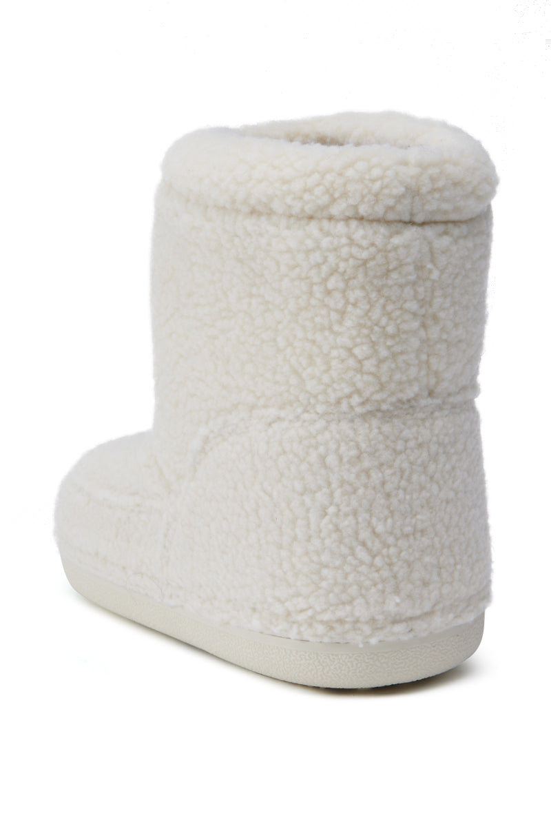 The AZALEA WANG SWEETING WHITE SHERPA BOOTIE is displayed from a back angle, showcasing its intricate stitching and design details in cream-colored, textured fleece fabric. Its high-top style features an ankle-high shaft and a lighter shade flat sole that enhances its cozy charm.