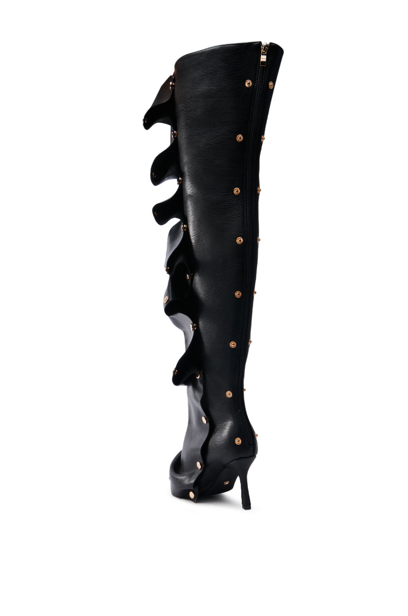 The AZALEA WANG SWELCIE BLACK PU GOLD HARDWARE STILETTO BOOT is a single faux leather thigh-high stiletto featuring a black exterior with gold studs, decorative ruffles, pointed toe, side zipper, and subtle visible sole and inner lining.