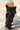 A person in distressed denim shorts and AZALEA WANG SWELCIE chocolate brown folded and snap detail thigh high boots stands on a crosswalk.