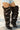 A person in frayed denim shorts and AZALEA WANG SWELCIE Chocolate Brown Folded and Snap Detail Thigh High Boots stands on a crosswalk.