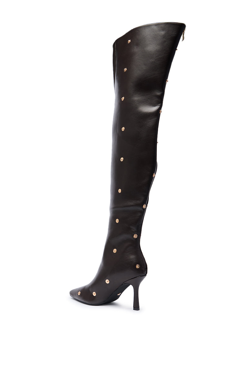 The AZALEA WANG SWELCIE Chocolate Brown Thigh High Boot features a pointed toe, gold snap details, sleek glossy faux leather, and a slim stiletto heel for a bold, sophisticated look. 6