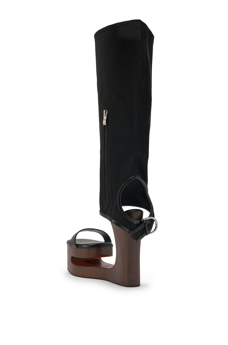 The AZALEA WANG SWINDLE BLACK NOVELTY WEDGE SANDAL is a unique black knee-high sandal with a high open-heeled wooden platform wedge, ankle strap, zippered mid-calf upper, and open toe, shown against a white background. 5