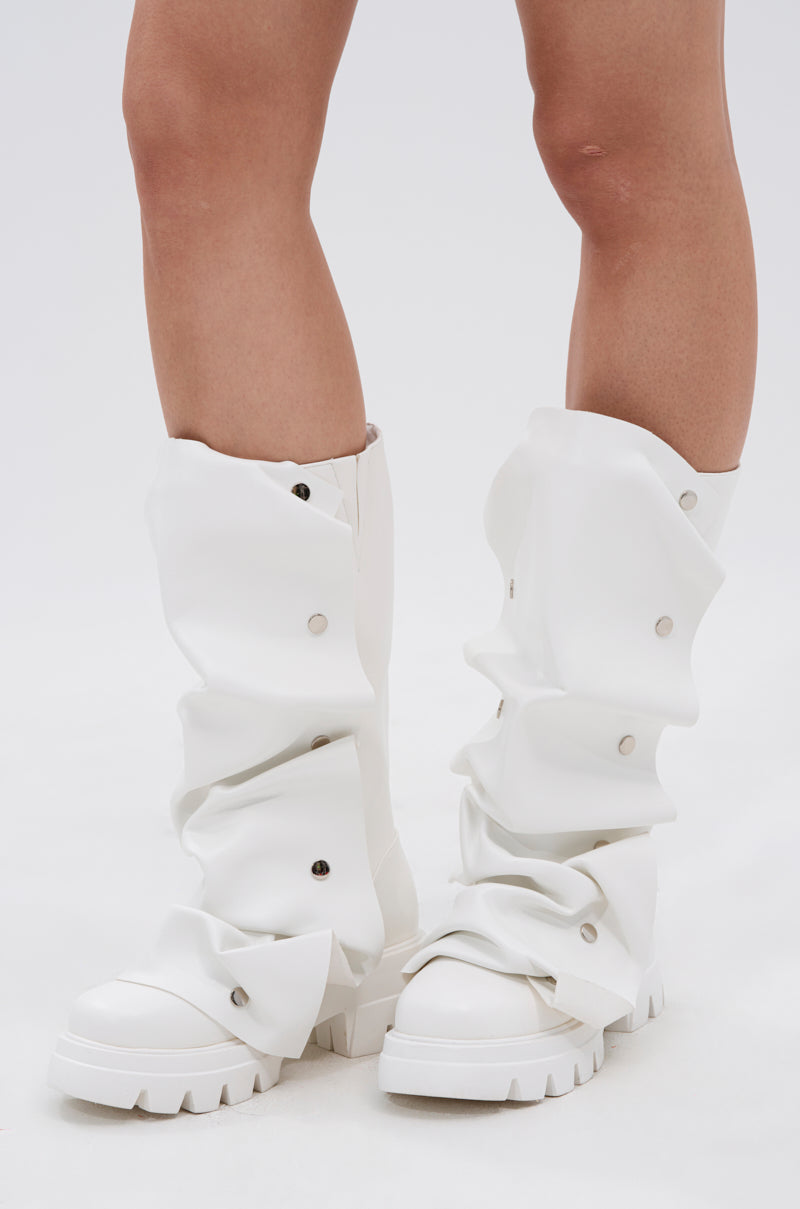 Someone wearing the AZALEA WANG SYBEL WHITE SNAP DETAIL BOOTIE, featuring chunky white faux leather, oversized loose coverings, and silver snap buttons, is standing on a white background.
