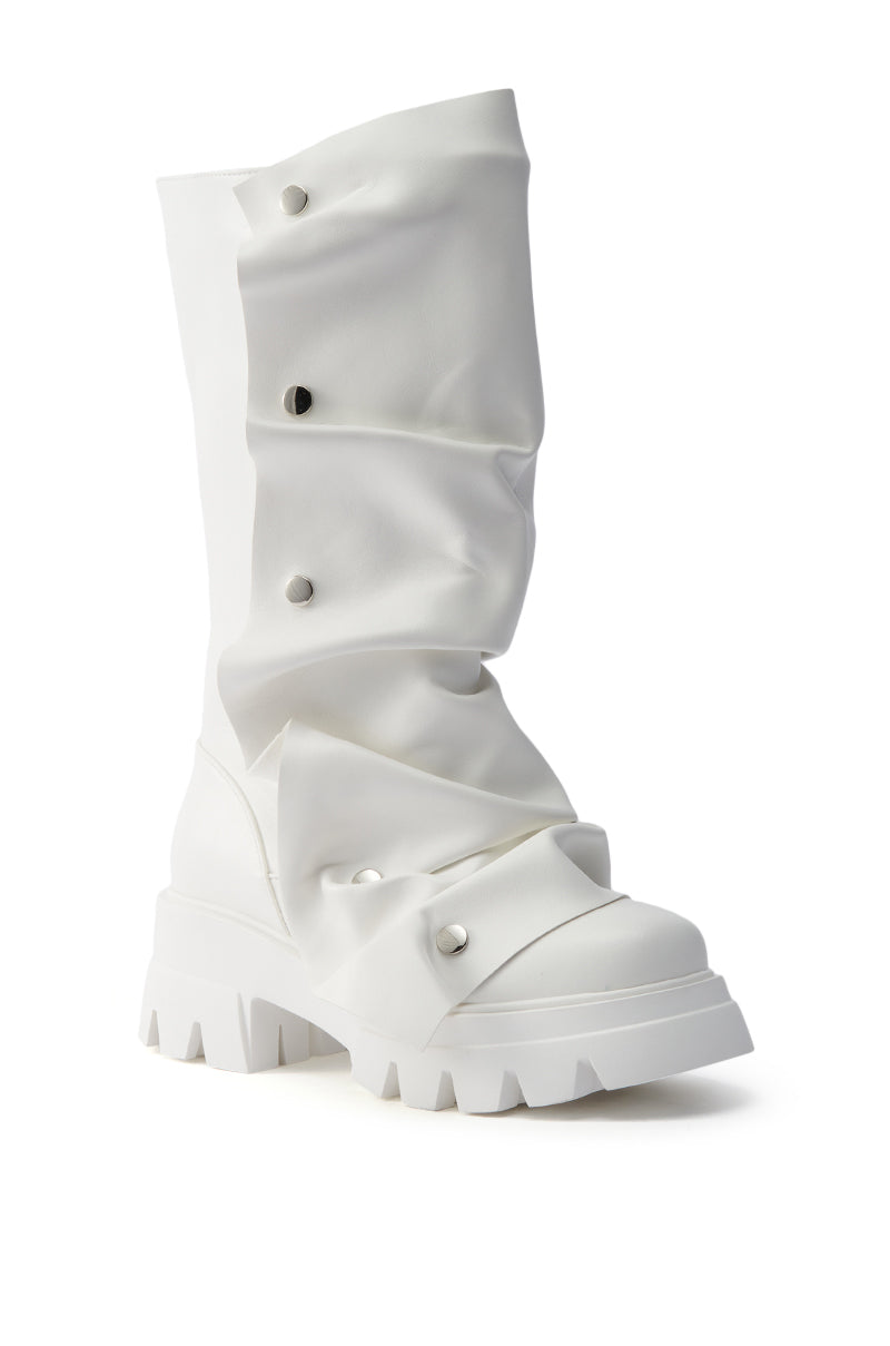 The AZALEA WANG SYBEL WHITE SNAP DETAIL BOOTIE features white faux leather, a chunky treaded sole, a tall slouched shaft, and decorative silver-toned snaps on folded layers.