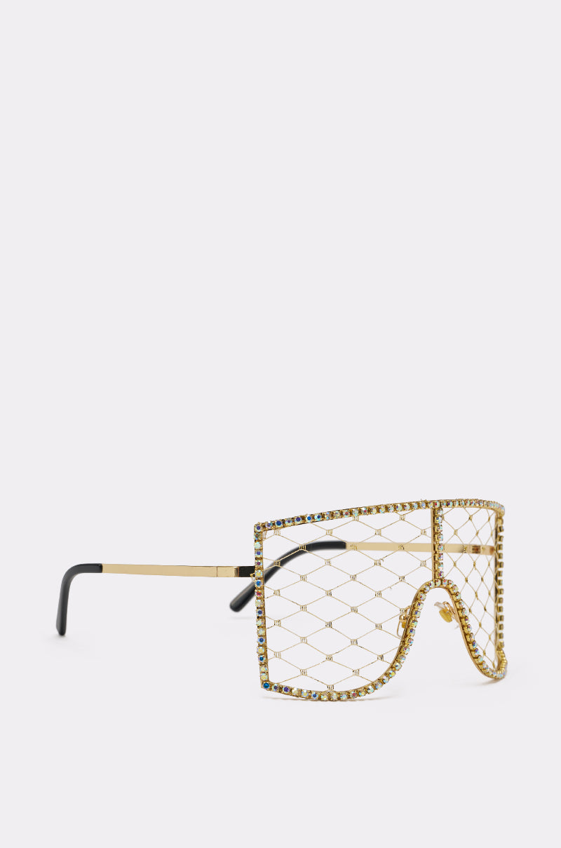 POP THE BUBBLY GLASSES IN GOLD: Gold monobrow sunglasses featuring a netted wire design and rhinestone accents around the frame, shown on a plain light background. 2