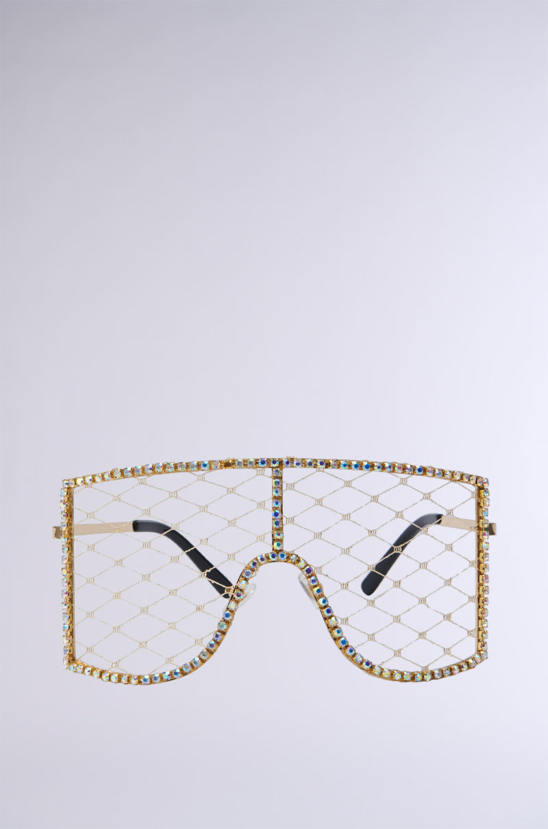 Introducing the Pop The Bubbly Glasses in Gold, featuring a distinctive faux gold metallic lattice frame embellished with multicolored rhinestones. The lenses are integrated into the lattice design with gold mesh filling in for where traditional lenses would be. These stylish sunglasses also come with sleek black temples. 1