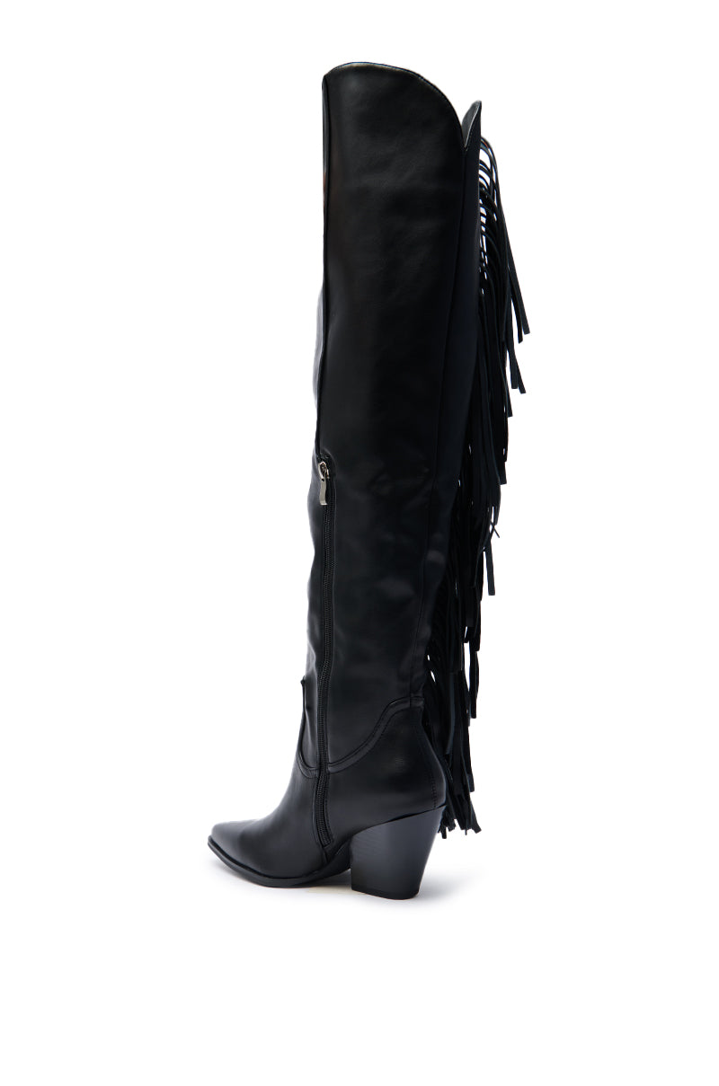 The AZALEA WANG SZYMON Black Western Boot features knee-high faux leather, a pointed toe, chunky heel, side zipper, and long fringe along the back, shown against a white background.
