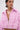 A woman with slicked-back hair and facial piercings wears the BUBBLEGUM BUBBLE HEM BOMBER, a textured pink jacket with distressed fringe, wide collar, and cropped silhouette. Silver hoops and chest tattoos complete her bold look.