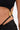 Close-up of a person wearing the TOO SEXY FOR THIS BODYSUIT in black, featuring gold metal ring detail at the waist and a daring cut-out, with gathered fabric for a bold, modern fit.