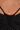 Close-up of a person's midriff wearing the TOO SEXY FOR THIS BODYSUIT—a black, ruched piece with thin straps that reveals their belly button and upper abdomen.