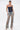 A woman models the KIMMY LACE UP DENIM CORSET with flame designs, paired with wide-leg light blue distressed jeans, hoop earrings, and open-toe heels, all set against a plain white background.