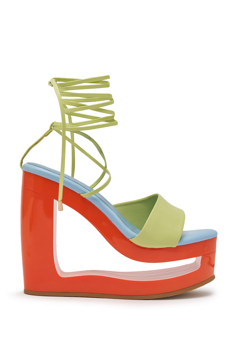 The AZALEA WANG TAFFY MULTI NOVELTY WEDGE MULE SANDAL features a chunky, hollow red wedge heel, a light blue footbed, a light green toe strap, and matching green ankle lace-up wrap laces. 3