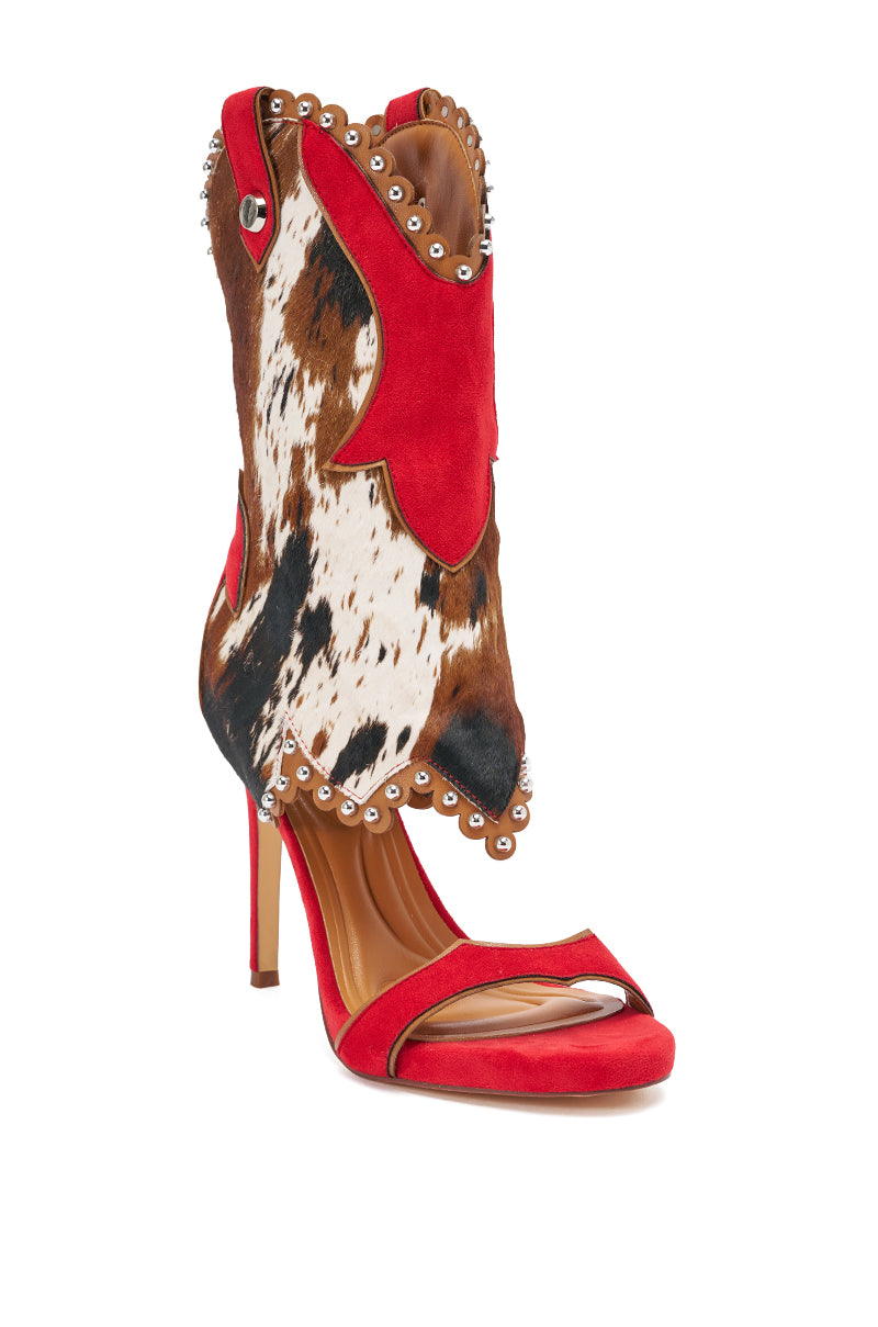 The AZALEA WANG TAHLIE COW MULTI WESTERN GLADIATOR SANDAL is a high-heeled sandal with a stiletto heel, red sole, strappy design, and tall red suede and cow print upper featuring metal stud details. 7