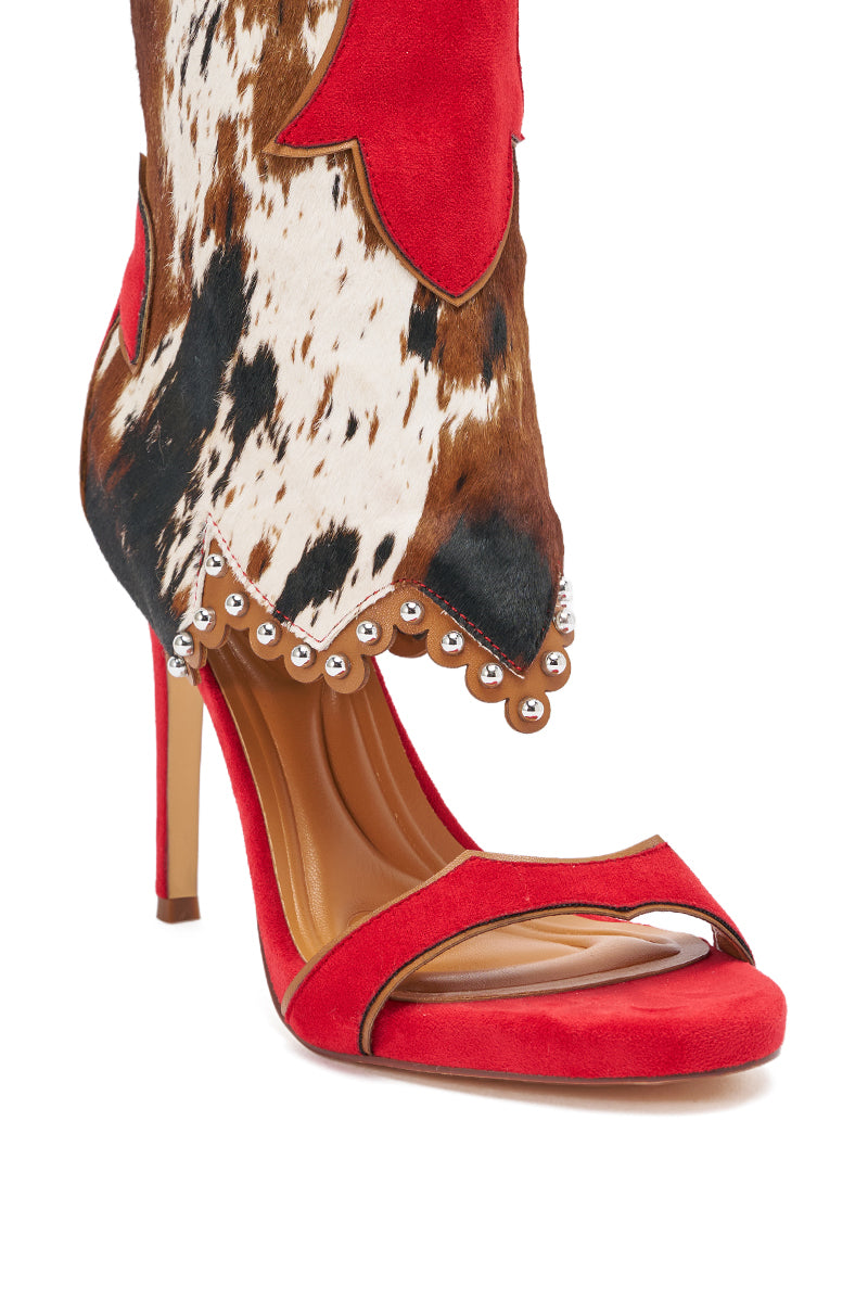 The AZALEA WANG TAHLIE COW MULTI WESTERN GLADIATOR SANDAL features a red suede strap, an attached cowhide boot with scalloped trim and silver bead accents, a stiletto heel, and tan heel and insole. 9