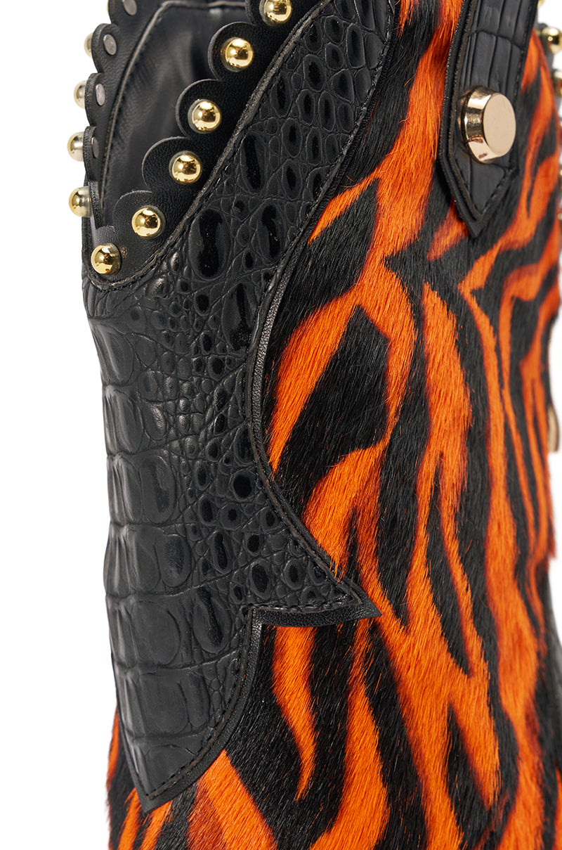 The AZALEA WANG TAHLIE ORANGE MULTI WESTERN GLADIATOR SANDAL features orange and black tiger-striped accents, black crocodile-embossed details, gold studs, and a round button—ideal for making a bold statement look.