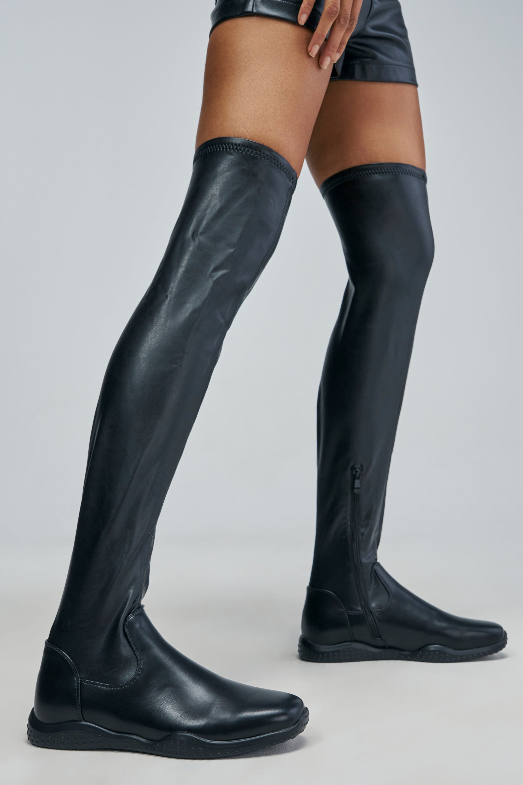 AZALEA WANG TALORIN BLACK OVER THE KNEE FLAT STRETCH PU BOOT in black faux leather with side zippers and textured soles.