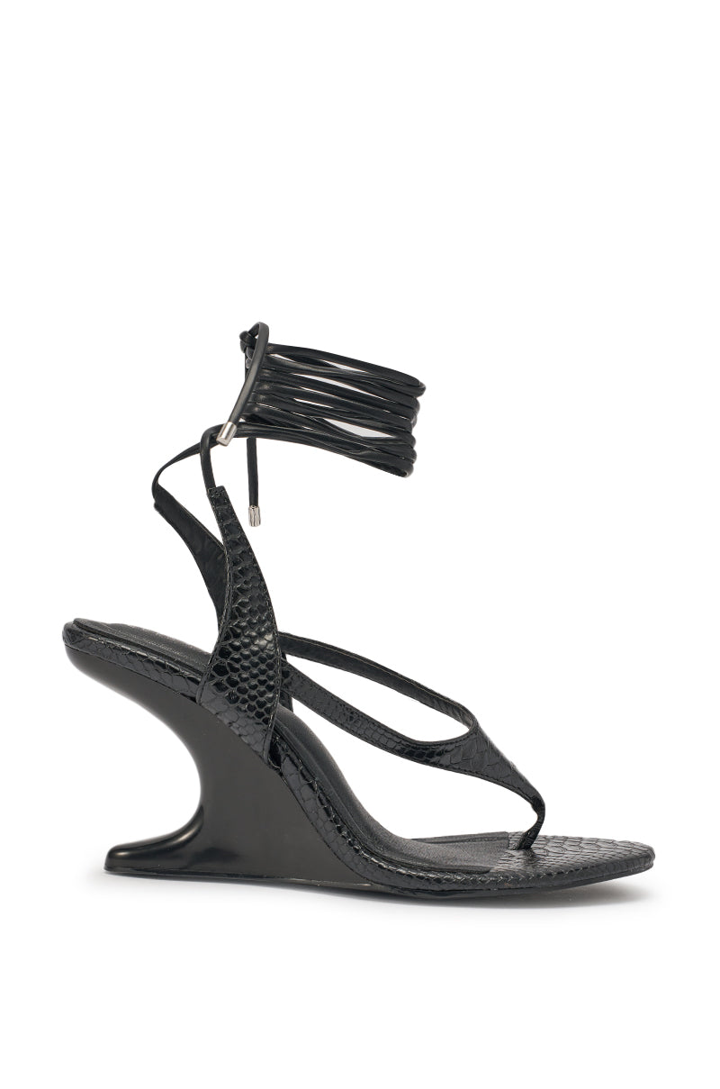 The AZALEA WANG TAMSIN BLACK CROC NOVELTY WEDGE STRAP SANDAL features black faux croc leather, a sculpted wedge heel, textured finish, thin straps, and an ankle wrap tie with metal tips—ideal as a statement sandal for evenings. 3