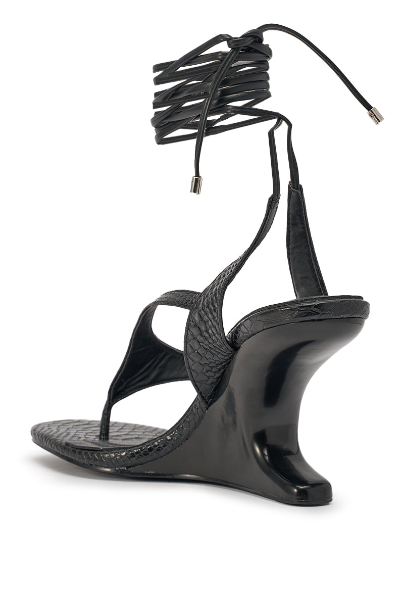The AZALEA WANG TAMSIN BLACK CROC NOVELTY WEDGE STRAP SANDAL features black faux croc leather, a sculpted heel, textured snakeskin pattern, and long wrap-around ankle laces with metallic tips—ideal for evening statement style. 5