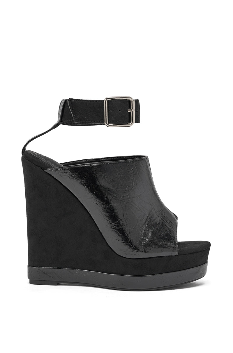 The AZALEA WANG TANA BLACK MIXED MATERIAL WEDGE features a high platform, peep toe, and ankle strap with silver buckle. Its shiny faux leather upper contrasts with a stylish matte wedge and platform for a chic look. 3