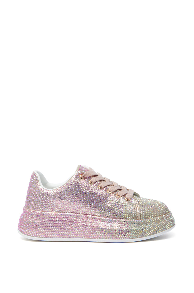 The AZALEA WANG TANGY PINK OMBRE RHINESTONE SNEAKER, with pink and gold rhinestones, an almond toe, low platform sole, white interior, and matching laces, is depicted from the side against a plain white background.
