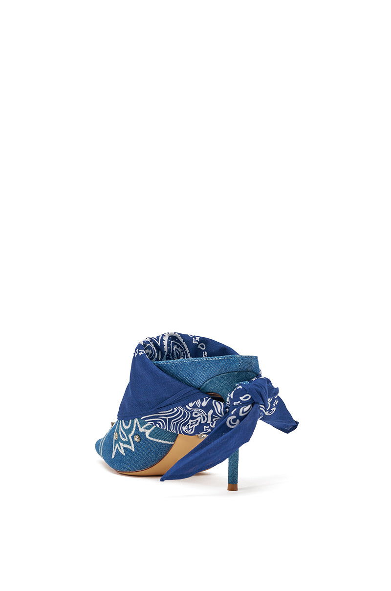The AZALEA WANG TAVINE Denim Mule Pump features a blue denim design with a pointed toe, paisley bandana detailing, and a bandana tied around the stiletto heel. Shown from the back. 7