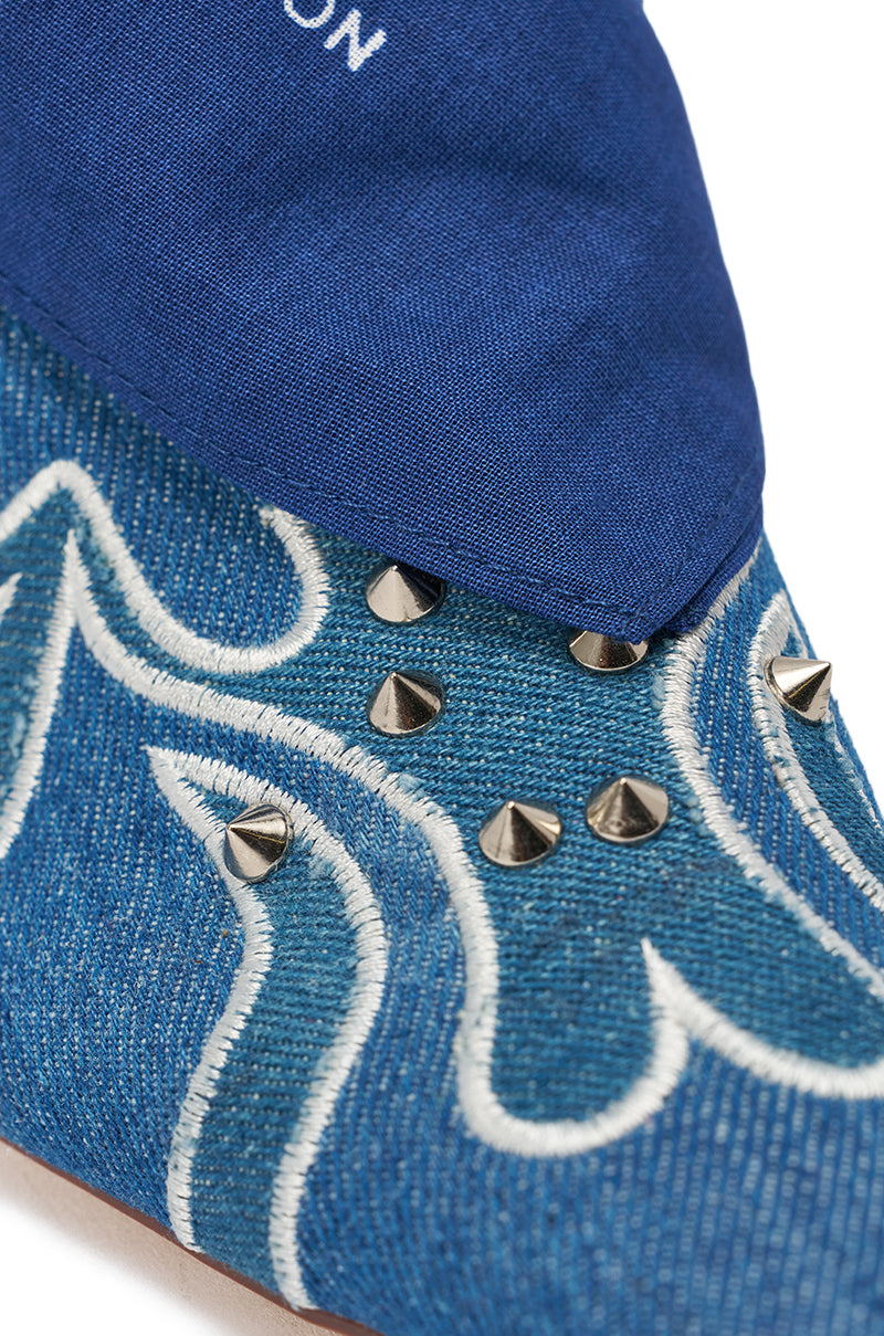 Close-up of the AZALEA WANG TAVINE DENIM MULE PUMP WITH BANDANA DETAIL, featuring blue denim, stiletto heel, white stitched wave patterns, silver cone studs, and a blue bandana overlay at the top. 8