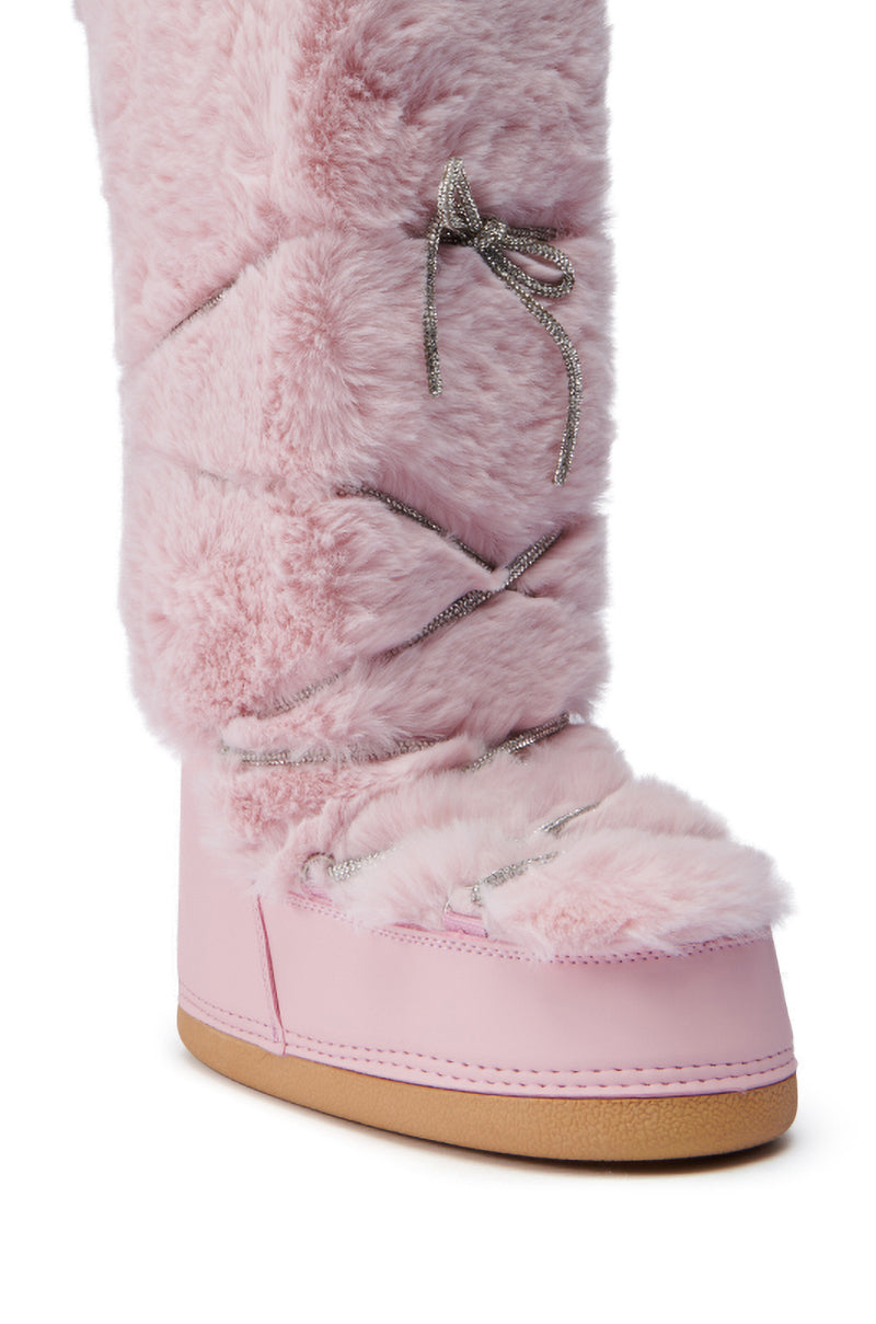 Close-up of the AZALEA WANG TAYTON PINK FUZZY FLAT KNEE HIGH BOOT, showcasing its pink faux fur upper and smooth light brown sole. The boot features crisscrossing silver laces and a plush, fluffy texture, providing a cozy and fashionable look.
