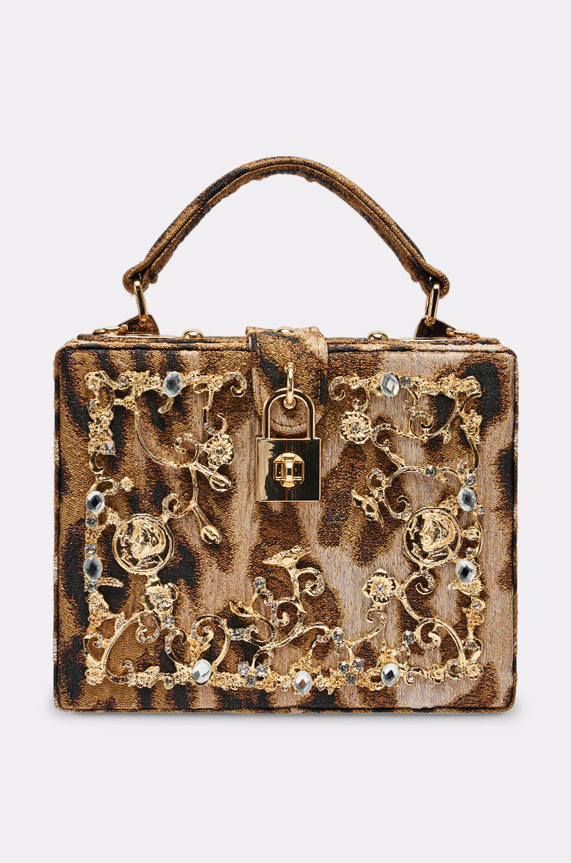 The DOLCE CHEETAH PURSE features a rectangular silhouette, cheetah print, gold floral embroidery, jeweled accents, top handle, and gold padlock clasp—an ideal luxury crossbody for those seeking standout style.