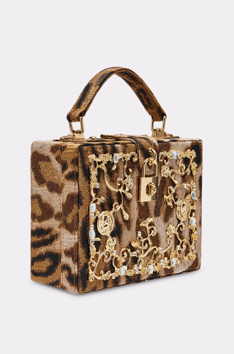 The DOLCE CHEETAH PURSE features a box shape, bold brown and black cheetah print, gold hardware and embellishments, faux pearls, and a gold padlock—making it the perfect statement luxury crossbody bag.