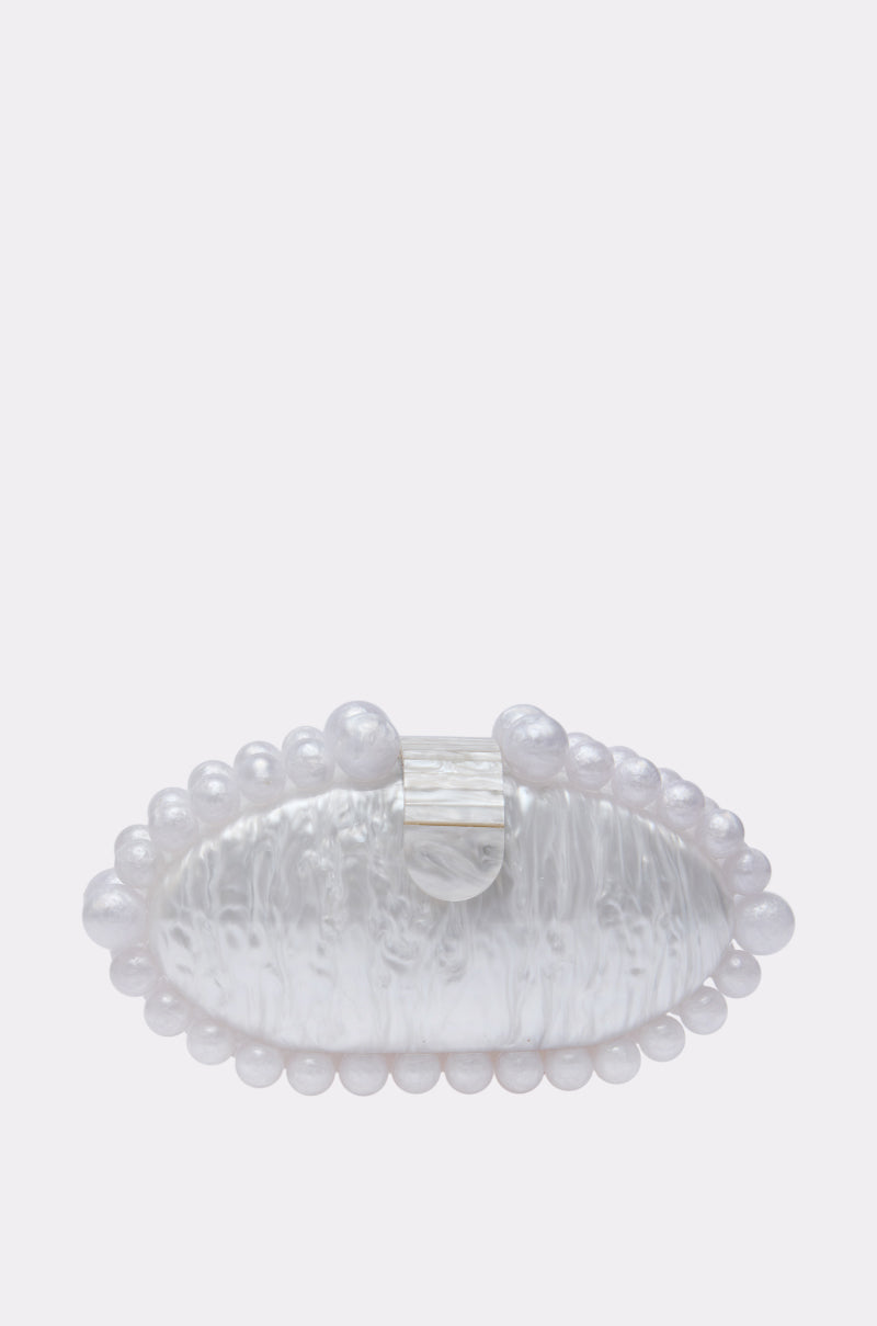 The EXPENSIVE TASTE CLUTCH is an oval, translucent barrette with a textured opalescent acrylic surface, faux pearl trim along the edge, and a central rectangular clasp, displayed on a plain light background. 0